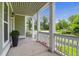 Inviting front porch with white columns, and outdoor lighting offering a cozy space at 5242 E Dolphin St, North Charleston, SC 29405