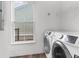 Convenient laundry room features modern washer and dryer set and natural light from a window at 5242 E Dolphin St, North Charleston, SC 29405