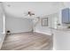 Open-concept living area with wood-look floors, ceiling fan, staircase and a view to the kitchen area at 5242 E Dolphin St, North Charleston, SC 29405