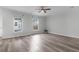 Bright living room with light wood floors, ceiling fan, and views of the front yard through the windows at 5242 E Dolphin St, North Charleston, SC 29405