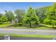 A serene street view showcasing a pond framed by mature trees and lush greenery at 5242 E Dolphin St, North Charleston, SC 29405