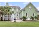 Backyard featuring a patio, deck, palm trees, green siding and a lush, green lawn at 591 Two Mile, Johns Island, SC 29455