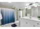 Bright bathroom featuring a white vanity, toilet, shower with blue curtain, and neutral wall color at 591 Two Mile, Johns Island, SC 29455
