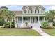 Charming two-story home featuring a spacious porch, well-manicured lawn, and lush tropical landscaping at 591 Two Mile, Johns Island, SC 29455