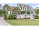 Beautiful home with a lush green lawn, a spacious porch, and elegant landscaping with various plants at 591 Two Mile, Johns Island, SC 29455