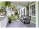 Relaxing front porch with a cozy porch swing, lush plants, and a view of the beautifully landscaped yard at 591 Two Mile, Johns Island, SC 29455