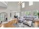 Spacious living room with hardwood floors, a high ceiling, a large grey sofa, and natural light at 591 Two Mile, Johns Island, SC 29455