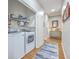 Functional laundry room with washer, dryer, shelving, and hall access at 605 Grassy Hill Rd, Summerville, SC 29483