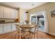 Sunlit dining area features wood floors, a round table with four chairs, and sliding door to patio at 708 Professor Dr, Ladson, SC 29456