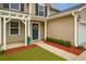 Inviting front porch with a blue door, decorative wreath, and manicured bushes at 708 Professor Dr, Ladson, SC 29456