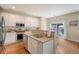 Well-lit kitchen features stainless steel appliances, white cabinetry, and breakfast bar for casual dining at 708 Professor Dr, Ladson, SC 29456