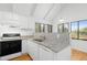 White kitchen cabinets, granite countertops, and stainless steel appliances are complemented by bright natural light at 811 Treeloft Trce, Seabrook Island, SC 29455
