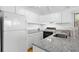 A closer view of the kitchen, showcasing white cabinets, stone countertops and stainless steel appliances at 811 Treeloft Trce, Seabrook Island, SC 29455