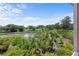 Scenic view of a tranquil pond surrounded by lush greenery and a golf course in the background at 811 Treeloft Trce, Seabrook Island, SC 29455