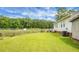 Spacious backyard featuring a lush lawn, a wooded fence, and partial side view of house at 8692 Bentwood Dr, North Charleston, SC 29406