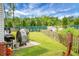 Backyard featuring a grassy area, a wooden fence, and an assortment of equipment at 8692 Bentwood Dr, North Charleston, SC 29406