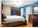 Spacious bedroom with a blue accent wall, a wooden dresser, and ample natural light at 8692 Bentwood Dr, North Charleston, SC 29406