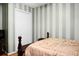 This bedroom features vertical striped wallpaper, a bed, and closet space at 8692 Bentwood Dr, North Charleston, SC 29406