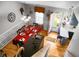 View of the dining room with hardwood floors, a red tablecloth, and access to the kitchen at 8692 Bentwood Dr, North Charleston, SC 29406