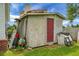 Exterior view of the backyard shed, with a red door and miscellaneous items around it at 8692 Bentwood Dr, North Charleston, SC 29406