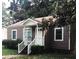 Charming single-story home with brown siding, white trim, and a cozy front porch with a white railing at 8930 Selah St, North Charleston, SC 29406