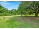 Expansive backyard with lush lawn, mature trees, and pond access, perfect for outdoor activities at 9049 Parlor Dr, Ladson, SC 29456