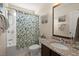 Cozy bathroom featuring a granite-topped vanity and shower with leaf-patterned curtain at 9049 Parlor Dr, Ladson, SC 29456