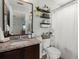 Well-lit bathroom featuring a granite vanity and decorative shelving for storage and style at 9049 Parlor Dr, Ladson, SC 29456