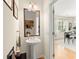 Stylish powder room featuring a pedestal sink, wood floors, and decorative mirror at 9049 Parlor Dr, Ladson, SC 29456