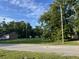 A residential neighborhood with lush greenery, utility poles, and single-story brick home at 9612 Hoot Owl Ave, Ladson, SC 29456