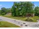 Street-level view of a commercial lot with mature trees and a sign for 9612 Hoot Owl Avenue at 9612 Hoot Owl Ave, Ladson, SC 29456
