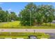 Street view of a commercial property with mature trees and a well-maintained lawn and parking at 9612 Hoot Owl Ave, Ladson, SC 29456