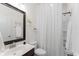 Bright bathroom features a vanity, toilet, shower with curtain, and decorative wall hangings at 9713 Cutleaf Dr, Ladson, SC 29456