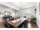 Bright dining room features a dark wood table, seating for eight, and view to the entryway and windows at 9713 Cutleaf Dr, Ladson, SC 29456