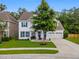 Beautifully landscaped front yard with a two-story home and a three-car garage at 9713 Cutleaf Dr, Ladson, SC 29456