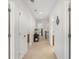Well-lit hallway with neutral walls, multiple doors, and carpet flooring at 9713 Cutleaf Dr, Ladson, SC 29456