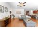Spacious living room with hardwood floors, modern furniture, and open layout to the kitchen at 9713 Cutleaf Dr, Ladson, SC 29456