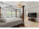 Bright and spacious main bedroom with a canopy bed, a dresser, and a large television for entertainment at 9713 Cutleaf Dr, Ladson, SC 29456