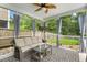 Comfortable screened porch with a ceiling fan, seating area, and a view of the serene backyard at 9713 Cutleaf Dr, Ladson, SC 29456