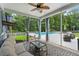 Cozy screened porch featuring a ceiling fan, comfortable seating, and a view of a private pool and backyard at 9713 Cutleaf Dr, Ladson, SC 29456