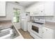 Functional kitchen with white appliances, tile floor, and stainless steel sink at 102 Sandy Hook Ct, Summerville, SC 29486