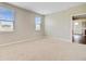 Bright bedroom featuring neutral carpet, two windows with blinds, and a view into an adjoining room at 104 Wild Orchid Way, Huger, SC 29450