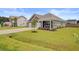 Well-maintained home exterior with manicured lawn, young trees and long driveway at 104 Wild Orchid Way, Huger, SC 29450