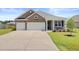 Charming home with a two-car garage, brick facade, and well-manicured lawn and driveway at 104 Wild Orchid Way, Huger, SC 29450