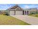 Beautiful home featuring two-car garage, large driveway and well-manicured lawn at 104 Wild Orchid Way, Huger, SC 29450
