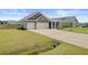 Attractive home with two-car garage, long driveway, and a well-maintained lawn at 104 Wild Orchid Way, Huger, SC 29450
