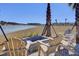 Outdoor community fire pit with Adirondack chairs and scenic water views creating a relaxing atmosphere at 104 Wild Orchid Way, Huger, SC 29450