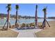 Community fire pit area featuring adirondack chairs surrounded by palm trees and water views at 104 Wild Orchid Way, Huger, SC 29450