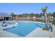 Inviting community pool featuring lounge chairs, umbrellas, and scenic views, ideal for relaxation at 104 Wild Orchid Way, Huger, SC 29450