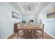 Elegantly staged dining room with seating for eight, modern light fixture, and hardwood floors at 107 Cotton Blossom Way, Summerville, SC 29485
